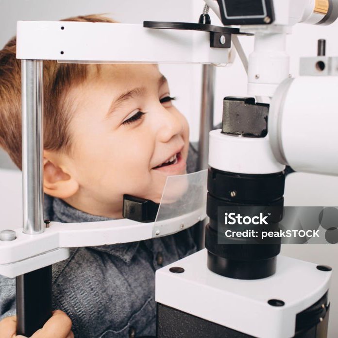 Happyboy receiving eye exam at clinic, eyesight examination children