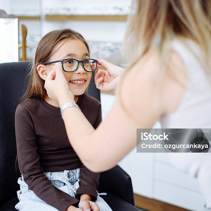 Picture of child optometry female optometrist optician doctor examines eyesight of little girl